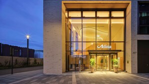 A modern building with a glass entrance and the name "Adina" displayed above. - Adina Apartment Hotel Cologne (Cologne)