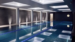 A modern indoor swimming pool with clear water, blue lane dividers, and recessed lighting on the ceiling. - Relaxing Studio Double Bed At Marylebone (London)