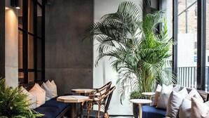 A modern lounge area with checkered flooring, seating arrangements, and large windows. - Relaxing Studio Double Bed At Marylebone (London)