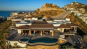 Un complex turístic amb diversos edificis, una piscina i vistes a l'oceà.