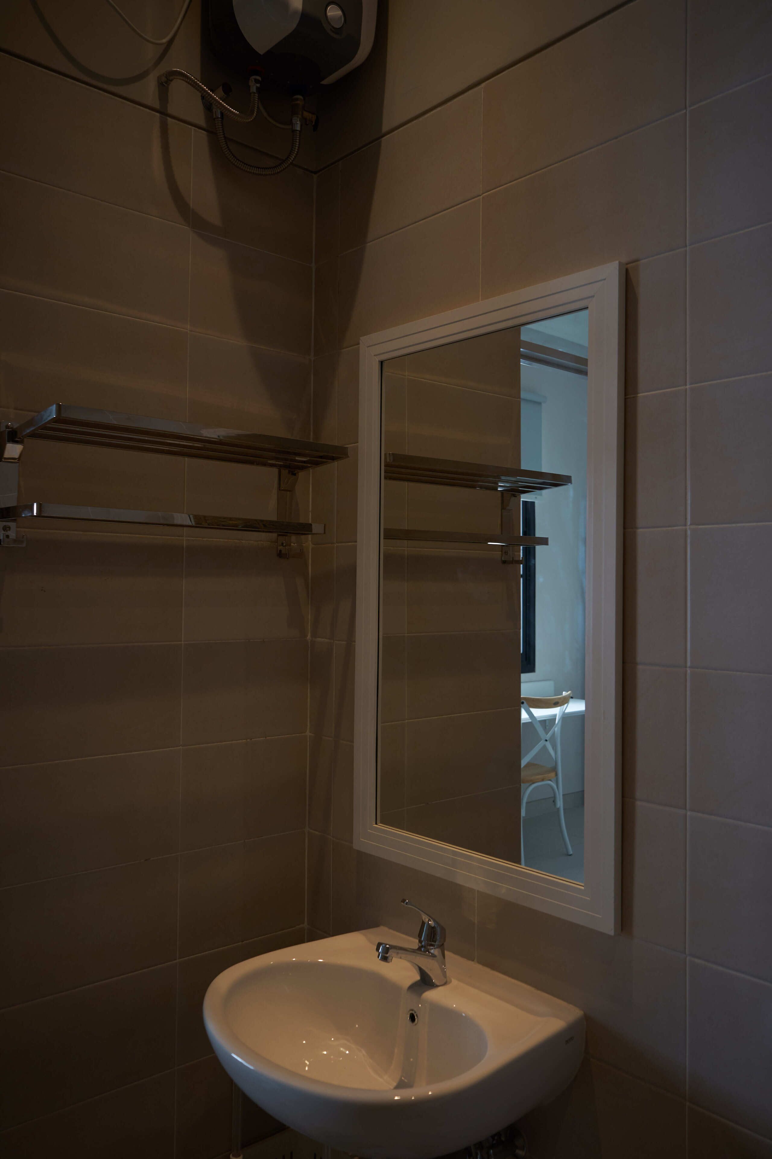 A bathroom with a white sink, a mirror, and a towel rack.