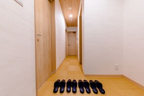 A hallway with wooden flooring and doors on both sides, leading to a room at the end. - Mt. Fuji Resort Club-MIYABI- (Fujikawaguchiko)