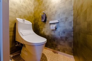 A modern bathroom with a toilet, a towel rack, and a paper towel dispenser. - Mt. Fuji Resort Club-MIYABI- (Fujikawaguchiko)