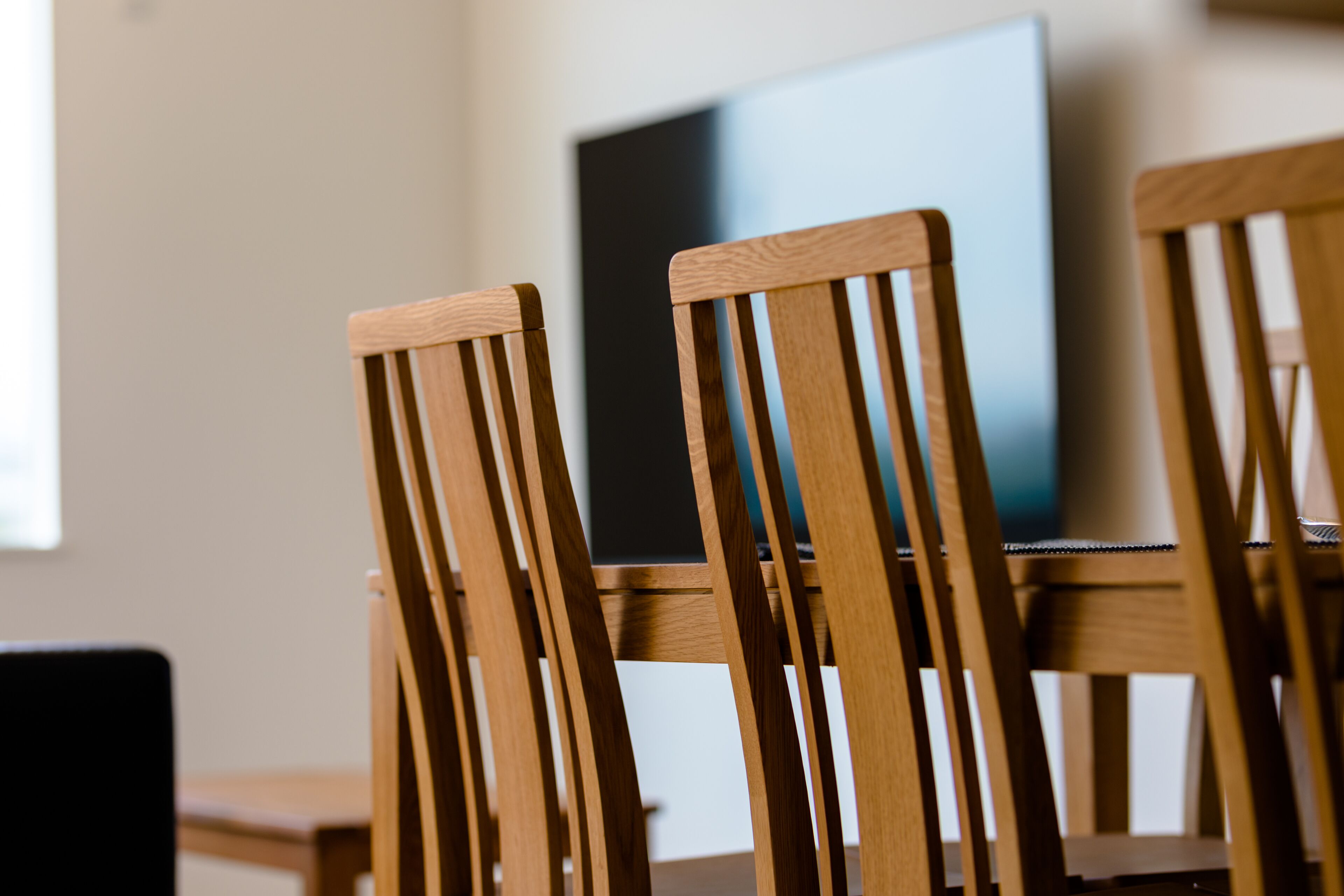 A dining area with wooden chairs and a table.