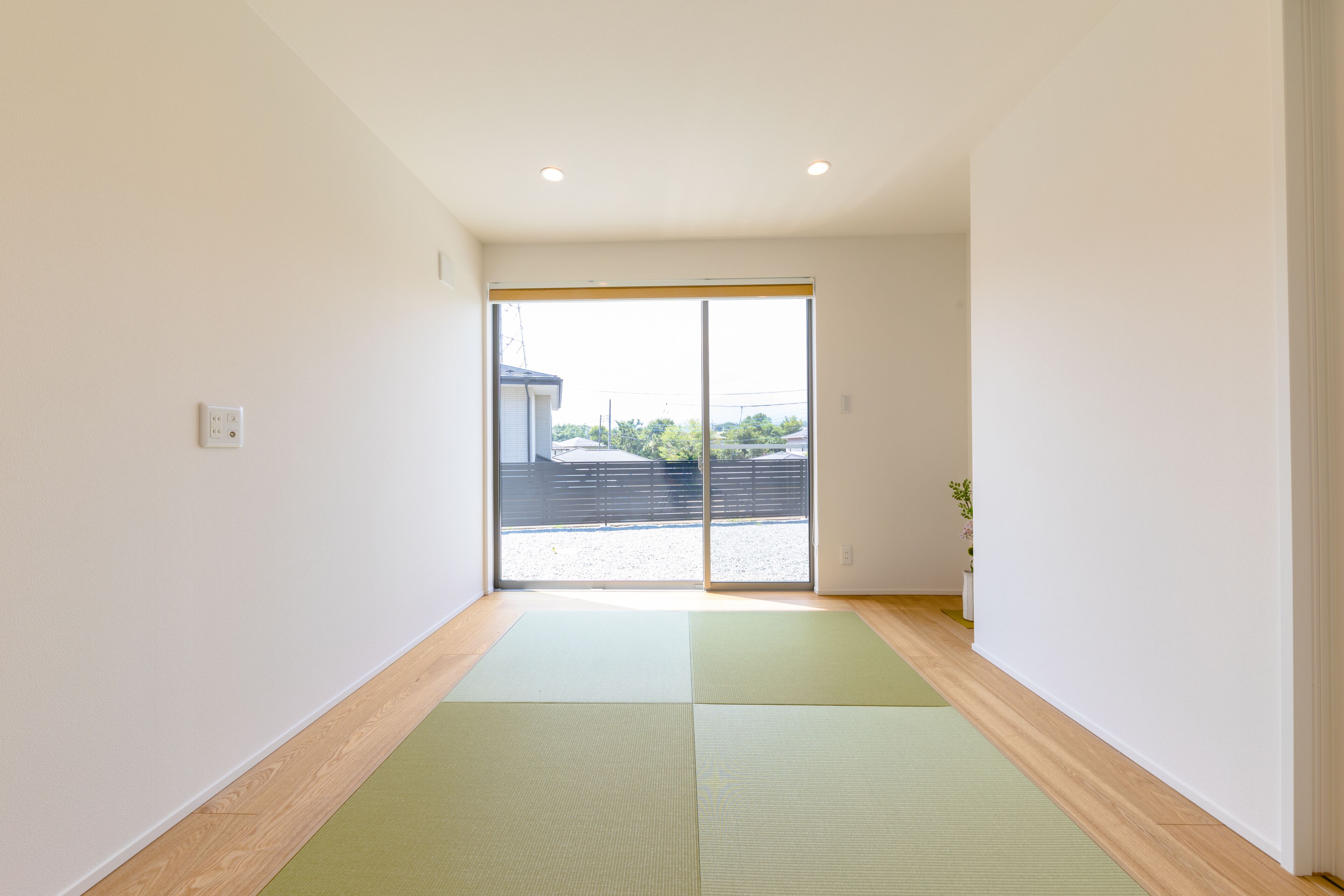 A hallway with a sliding glass door leading to an outdoor area.