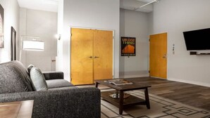 Una sala de estar moderna con un sofá, una mesa de centro y un cartel en la pared.