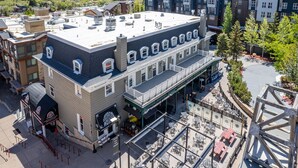 A multi-story building with a rooftop terrace, outdoor seating area, and a covered walkway. - Luxury five bedroom condo, outdoor swimming pool, walk to hiking and biking trails (Park City)