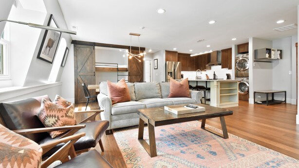 A modern living room with a sofa, coffee table, and patterned rug. - Luxury five bedroom condo, outdoor swimming pool, walk to hiking and biking trails (Park City)