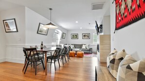 A modern living room with a dining area, featuring a sofa, chairs, and a coffee table. - Walk to Skiing, Stunning Top Floor Condo at Park City Base, Professionally Decorated Luxury 3BR (Park City)