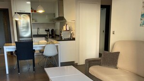 A modern living room with a white sofa, a coffee table, and a dining area with a table and chairs. - Ground floor Aqua Nature La Mata Costa Blanca (La Mata)