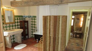 A bathroom with a sink, bathtub, and a shower curtain. - Historic 18th Century Home with Modern Comforts in Medieval Village (Montmirail)