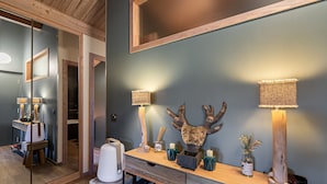 Une salle de bain moderne avec un meuble-lavabo en bois, un miroir et deux lampes fixées au mur.