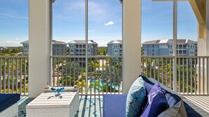 Un balcon avec vue sur une piscine et les bâtiments du complexe hôtelier.