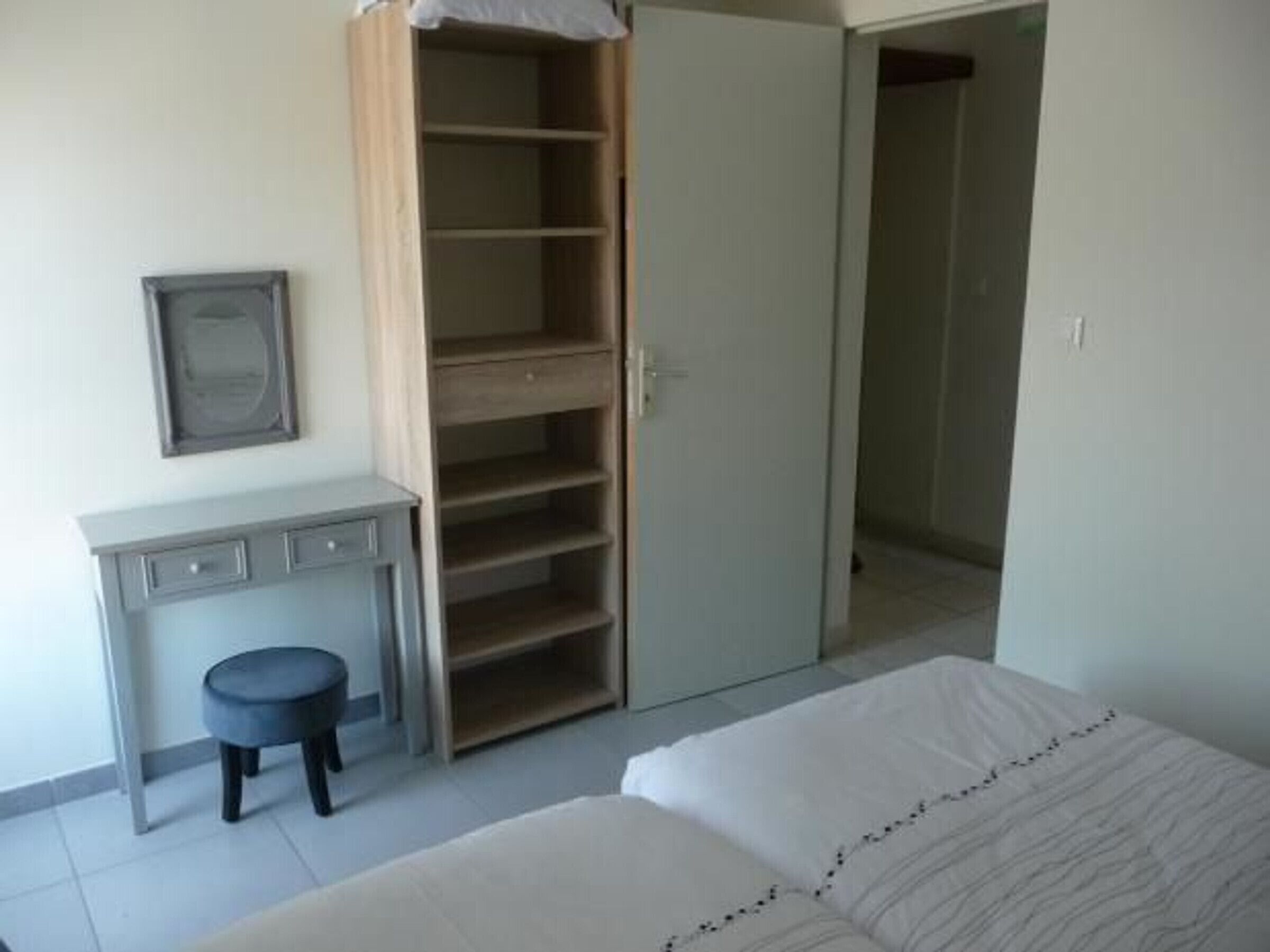 Un dormitorio con cama, escritorio, silla y armario.