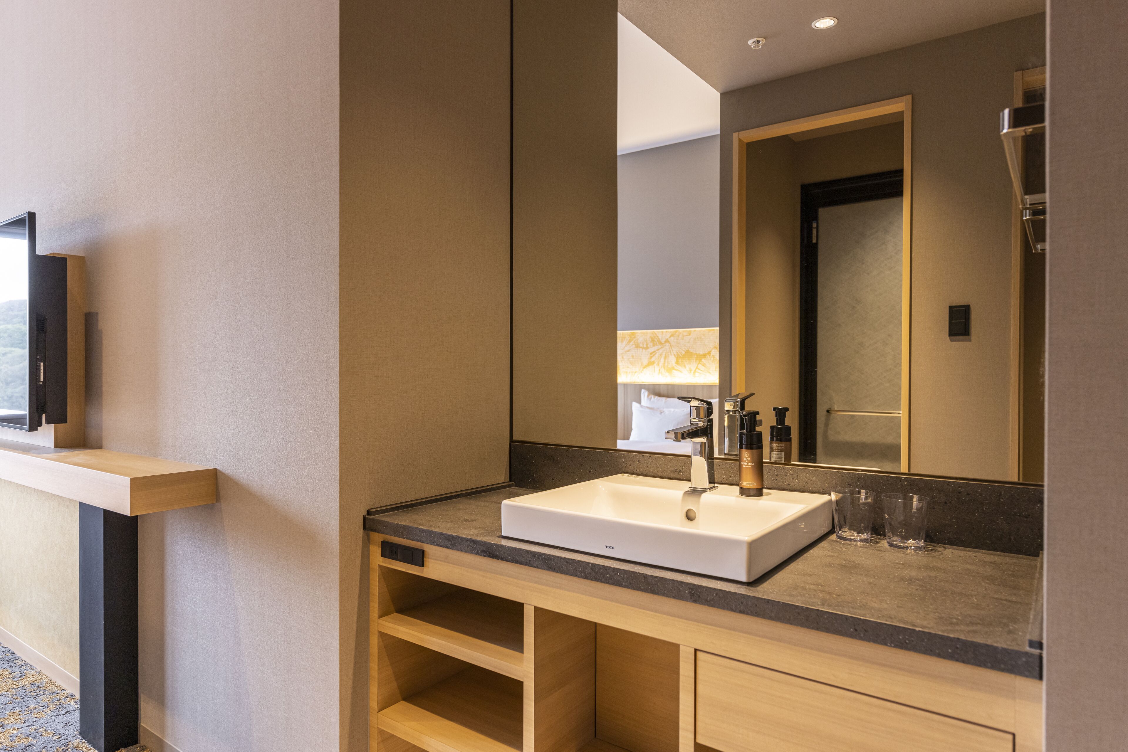 Un baño moderno con un espejo grande, un lavabo blanco y un mueble de tocador de madera.