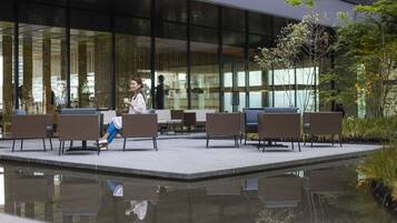 An outdoor seating area with wicker chairs and a reflective pool.