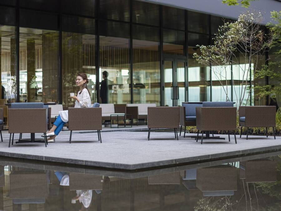 An outdoor seating area with wicker chairs and a reflective pool.
