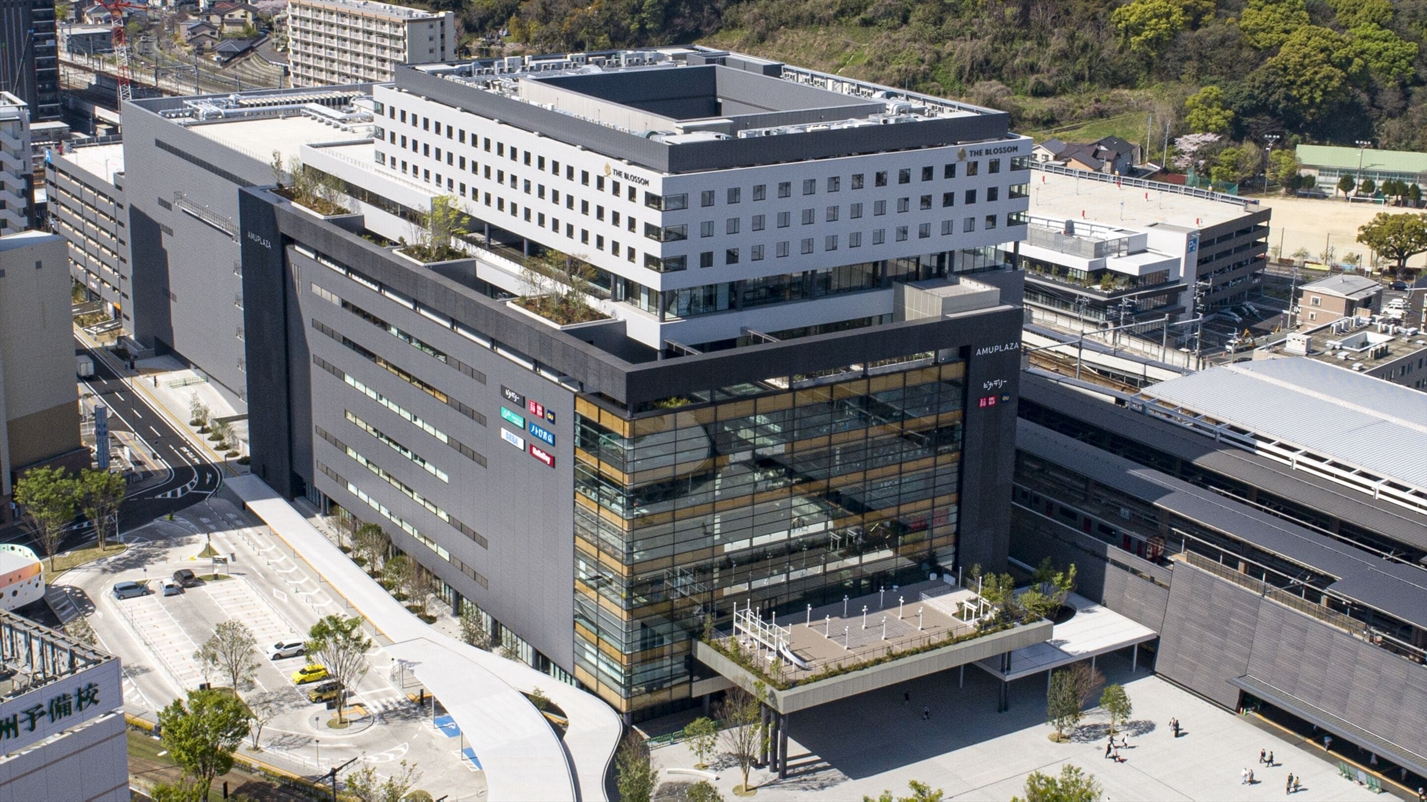A modern building with multiple floors, large windows, and a flat roof.
