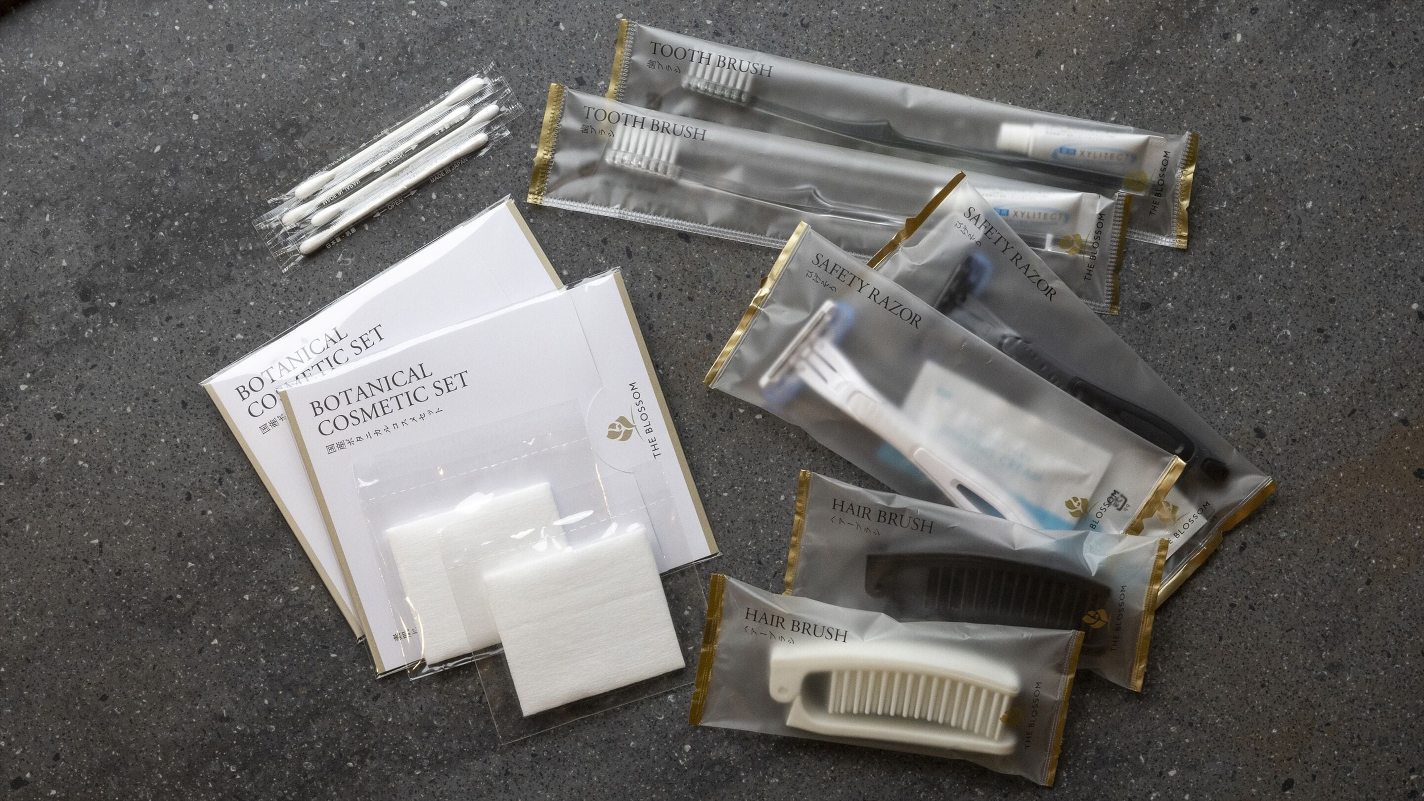 A collection of personal care items including a botanical cosmetic set, hairbrush, and safety razor, all packaged in branded containers.