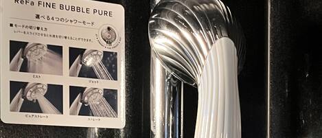 Un grifo de baño con una etiqueta ReFa FINE BUBBLE PURE y un manual con instrucciones en japonés.