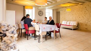 A dining area with a round table, chairs, and a sofa.