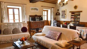 A cozy living room with a sofa, a coffee table with fruit, and a bookshelf.