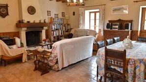 A cozy room with a fireplace, a bookshelf, a bed, and a dining table.