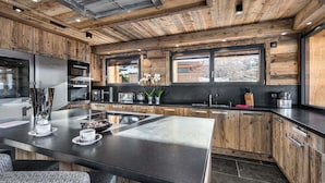 Eine moderne Küche mit Holzelementen, Edelstahlgeräten und einer großen Kochinsel.