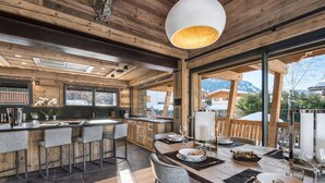 Eine moderne Küche mit Holzelementen, ein Essbereich mit Ausblick und ein großes Fenster.