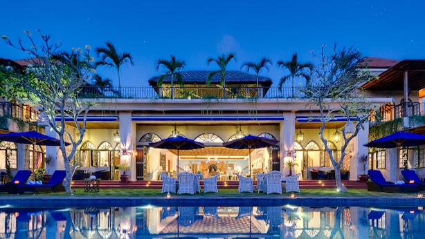 A hotel with a pool, outdoor seating, and a well-lit entrance. - Sayang d’Amour (Seminyak)