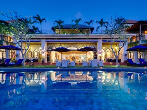 A hotel with a pool, outdoor seating, and a well-lit entrance. - Sayang d’Amour (Seminyak)