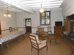 Un coin repas avec une table et des chaises, un téléviseur et une cheminée.