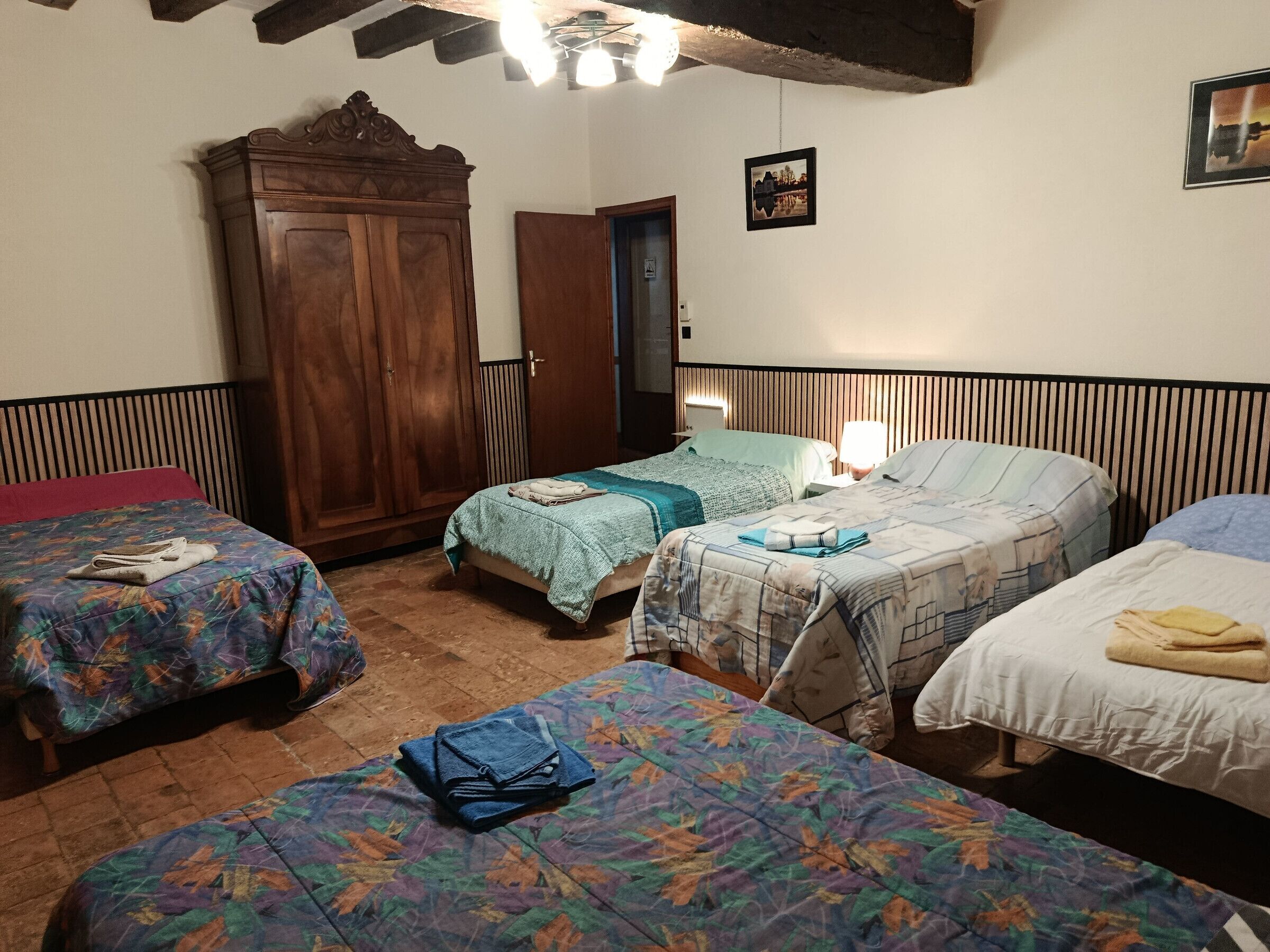 Une pièce avec trois lits, une armoire et une porte.
