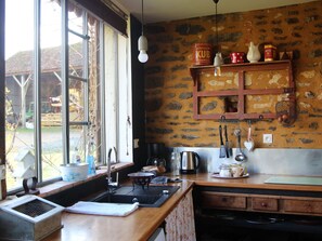 Enjoy cooking with a view from this kitchen, featuring a large window, sink, and coffee maker.