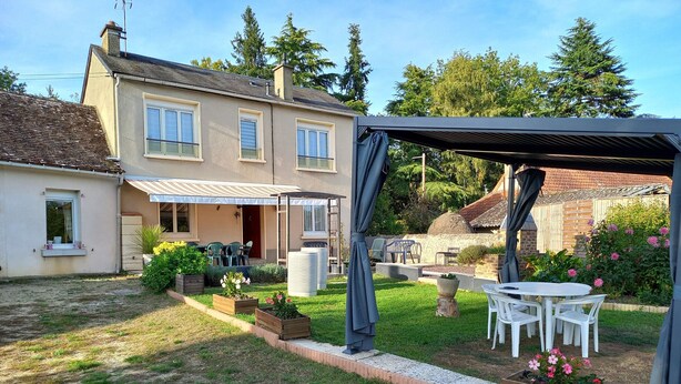 A two-story house with a patio area, outdoor seating, and a garden. - Spacieuse maison confortable avec jardin, à 20 min du centre-ville et proche du circuit des 24H du Mans (Le Mans)
