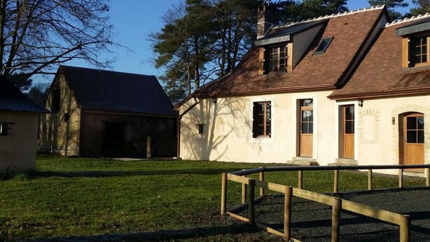 A traditional house with a sloped roof, a wooden fence, and a grassy yard. - Charming Cottage: 3BR, Cozy Fireplace, Large Garden, Near Bercé Forest (Saint-Mars-d'Outillé)