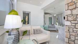 A modern living room with a white sofa, a glass coffee table, and a decorative lamp. - Dion  Villa with Pool in Zakynthos Greece (Zakynthos)