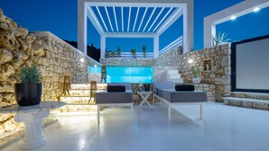 An outdoor patio with stone walls, a white pergola, and a pool area. - Dion  Villa with Pool in Zakynthos Greece (Zakynthos)