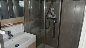 A bathroom with a glass-enclosed shower, a white sink, and a mirror above the sink. - Charming Country House with Garden, Terrace, Petanque & Fireplace Near Vernie (Vernie)