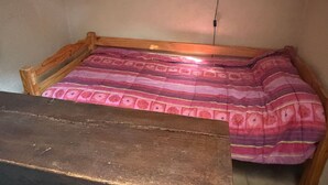 A single bed with a patterned bedspread, a wooden headboard, and a wall-mounted light fixture. - Charming Country House with Garden, Terrace, Petanque & Fireplace Near Vernie (Vernie)