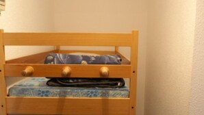 A bunk bed with two levels, each with a pillow and a blanket.