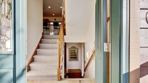 A staircase leading to a landing with a small wooden bench and a window.