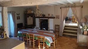 Un comedor con una mesa larga, sillas y chimenea.