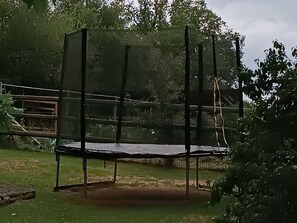 A fenced outdoor area with a trampoline.