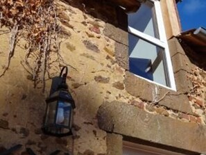 Een stenen gebouw met een raam en een hanglamp.