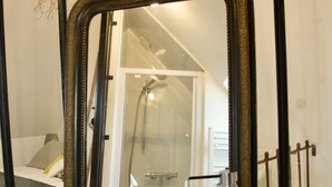 A bathroom with a large mirror, a bathtub, and a shower.
