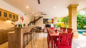 Une cuisine spacieuse avec un coin repas, un escalier et une vue sur la piscine.