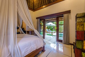Un dormitorio con cama con dosel, vistas al exterior y una pared colorida.