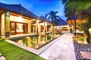 A resort with a swimming pool, thatched-roof structures, and a well-maintained garden. - Villa Cinta (Seminyak)