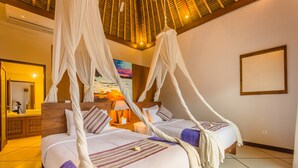A room with two beds, each with a canopy, a wooden headboard, and a nightstand with a lamp. - Villa Alore (Seminyak)